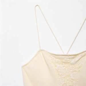 Close-up of cream lace embroidery and slim criss-cross straps on a summer camisole dress