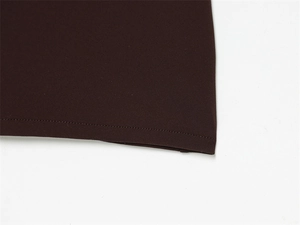 Detailed view of dark brown dress hem with precise stitching and high density fabric