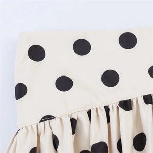 Detailed macro shot of polka dot fabric waistband with fine stitching and soft pleats