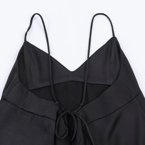 Detail of black satin camisole top showing slim straps and lace-up back structure