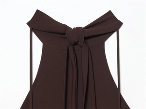 Detail of dark coffee halter neckline featuring elegant back tie-knot with draped ribbons