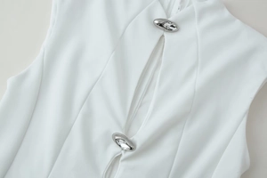 Vue détaillée du tissu blanc avec découpes et boutons argentés ornés de strass brillants