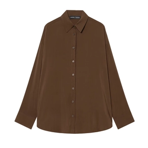 Détail d'une chemise marron foncé avec col en pointe et étiquette de marque interne