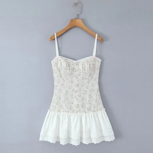 Detail of floral mini dress with lace trim, pink bow, and ruffled hem on hanger
