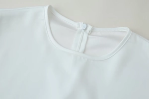 Detailed close-up of white blouse neckline featuring a hidden zipper and neat stitching