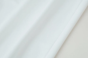 Gros plan sur un tissu blanc révélant une texture fine et un drapé souple élégant