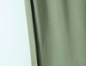 Close-up of olive green linen fabric texture with clean edge stitching and fine weaving