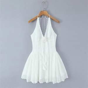 Close-up of white lace halter dress with deep V-neck and 3D floral accent on wood hanger