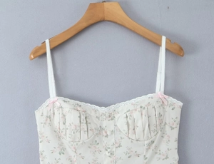Detailed view of floral tank top featuring white lace trim and pink ribbon bow detail
