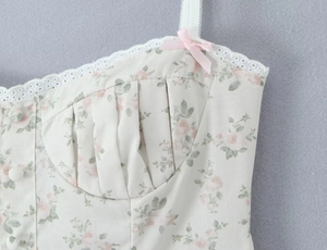 Detail of floral bustier top with delicate pink rose print and white lace trim