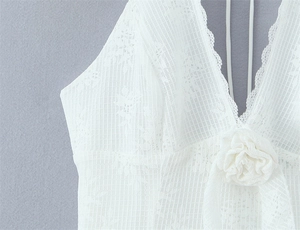Detail of white lace halter dress featuring 3D rose flower and eyelash lace trim