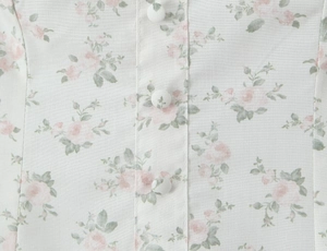 Detail shot of fabric texture with floral print and fabric-covered buttons on the dress