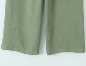 Detail of sage green wide-leg pants showing premium crinkled cotton linen fabric texture