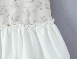 Detailed close-up of floral print and ruffled seam on a slim summer dress