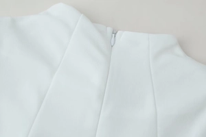 Détail macro d'une robe blanche montrant une fermeture éclair invisible et un tissu lisse