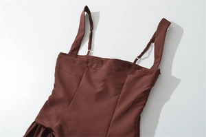 Detail of dark brown mini dress featuring adjustable thin straps and invisible zipper