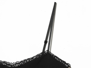 Close-up of adjustable thin shoulder straps and delicate black lace trim on dress neckline