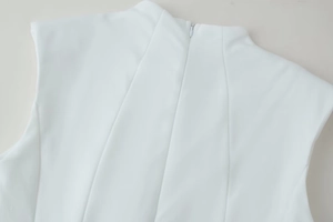Détail du dos d'une robe blanche sans manches avec fermeture éclair invisible et col