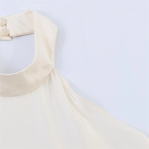 Detail of cream halter top neck design with silk texture and two back buttons
