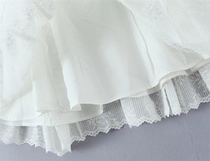 Detail shot of white lace floral embroidery with scallop edge and soft inner lining