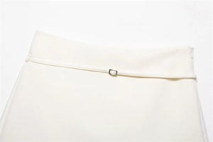 Detail view of white skirt waist with textured fabric belt and silver metal buckle