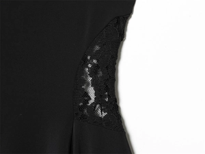 Close-up of intricate black lace cut-outs on the side of a sleek mini dress
