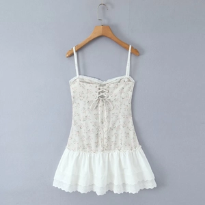 Detail of floral printed bodice with lace trim and layered pleated white ruffle hemline