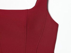Detail shot of burgundy sleeveless bodycon dress featuring structured corset stitching