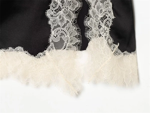 Gros plan détaillé du satin noir avec bordure en dentelle florale blanche de haute qualité