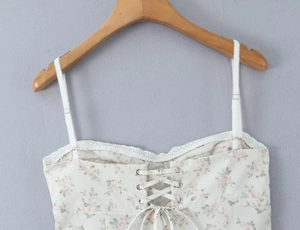 Detail of adjustable straps and lace trim on floral slim-fit summer camisole dress