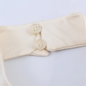 Detail shot of beige silk-like fabric featuring neat stitching and round button closures