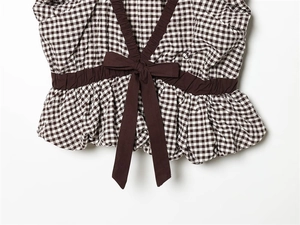 Detail des Gingham-Tops mit elastischer Taille, Zierschleife und gerüschtem Saumende