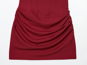 Detailed close-up of dark red mini dress featuring elegant ruched fabric and slim fit hem