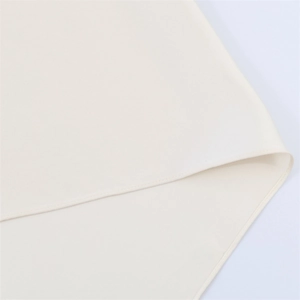 Close-up of clean hemline stitching on ivory halter top showing fine fabric texture