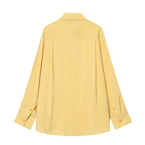 Détail des plis au dos et de la texture satinée de cette chemise jaune pâle