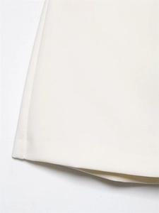 Detailed close-up of white woven fabric hem with neat stitching and smooth texture