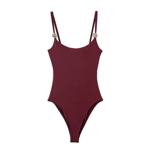 Sleek burgundy one-piece bodysuit with thin straps and metallic circular hardware accents