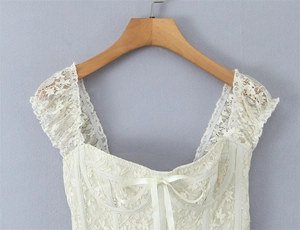 Detail of floral lace top with square neckline and delicate satin bow accent