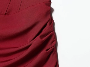 Detailed view of dark red fabric showing fine texture, elegant pleats and reinforced stitching