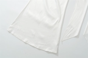 Macro shot of white satin fabric showing smooth texture and high-quality edge stitching
