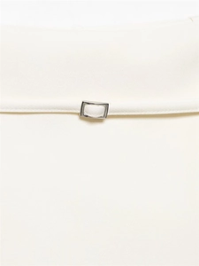 Detailed close-up of white high-waisted culottes with slim belt and silver buckle