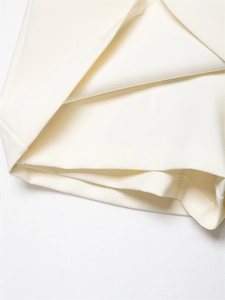 Close-up of ivory white woven fabric hem with precise stitching and refined texture