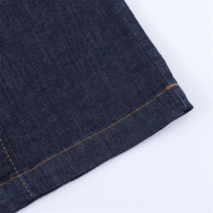 Détail de l'ourlet de robe en denim bleu foncé avec surpiqûres jaunes contrastées