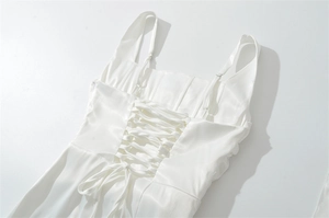 Detail of white satin dress featuring corset-style criss-cross lace-up back with a bow
