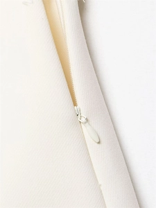 Macro shot of invisible zipper and fine diagonal twill fabric texture on beige skirt