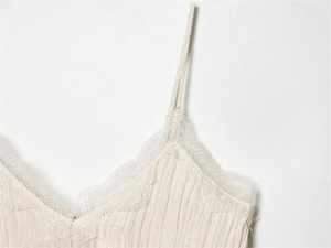 Detail eines beigen Camisole mit Wimpernspitze und plissiertem Stoff mit Textur