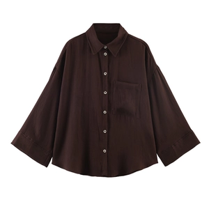 Detail view of coffee brown oversized shirt featuring a front pocket and textured fabric