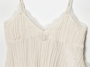 Detailansicht des V-Ausschnitts mit zarter Spitze am beigen Camisole-Top mit Falten