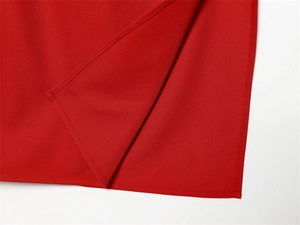 Close-up detail of high-quality red dress hem featuring precise stitching and woven fabric