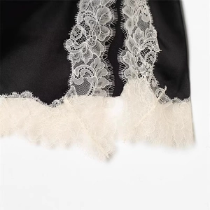 Robe chic en satin noir avec bordure en dentelle de cils blanche et fini soyeux
